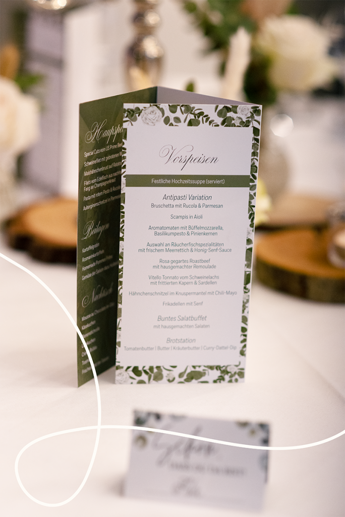 Beispielbild einer Menükarte im Hochzeitsdesign in grün mit Eukalyptus und weißen Rosen | Kremer Signature Design
