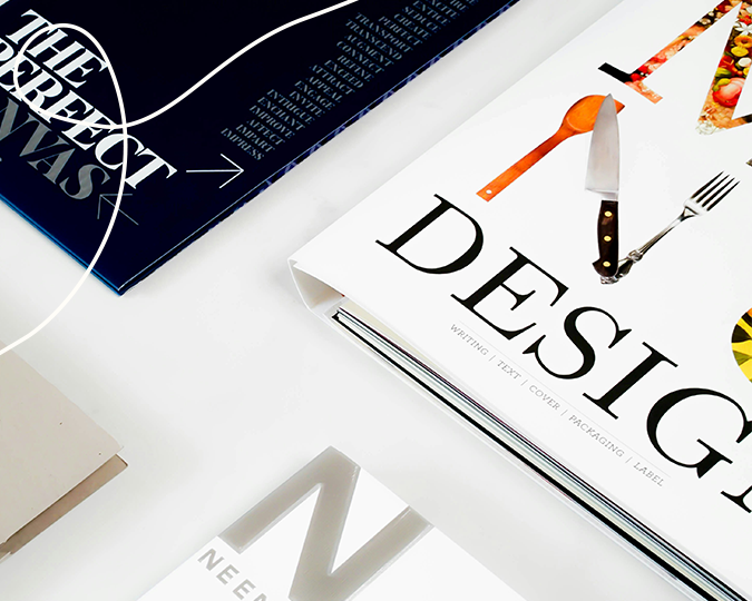 Sliderbild einer Nahaufnahme von Buchcover die ordentlich angeordnet wurden dazu eine helle geschwungenen Linie oben links in der Ecke als Gestaltungselement | Kremer Signature Design