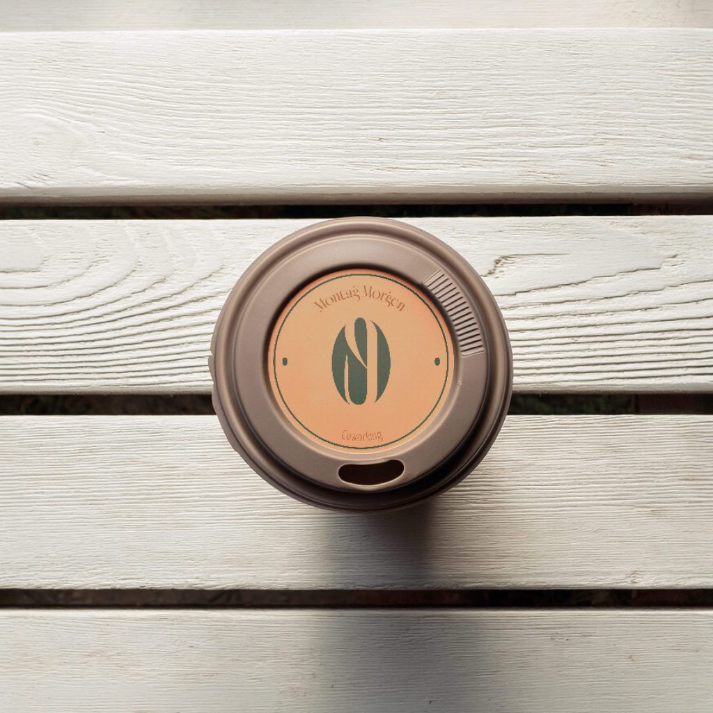 Submark für Montagmorgen dargestellt als Sticker auf einem Kaffeebecher togo Deckel beige/grün | Kremer Signature Design
