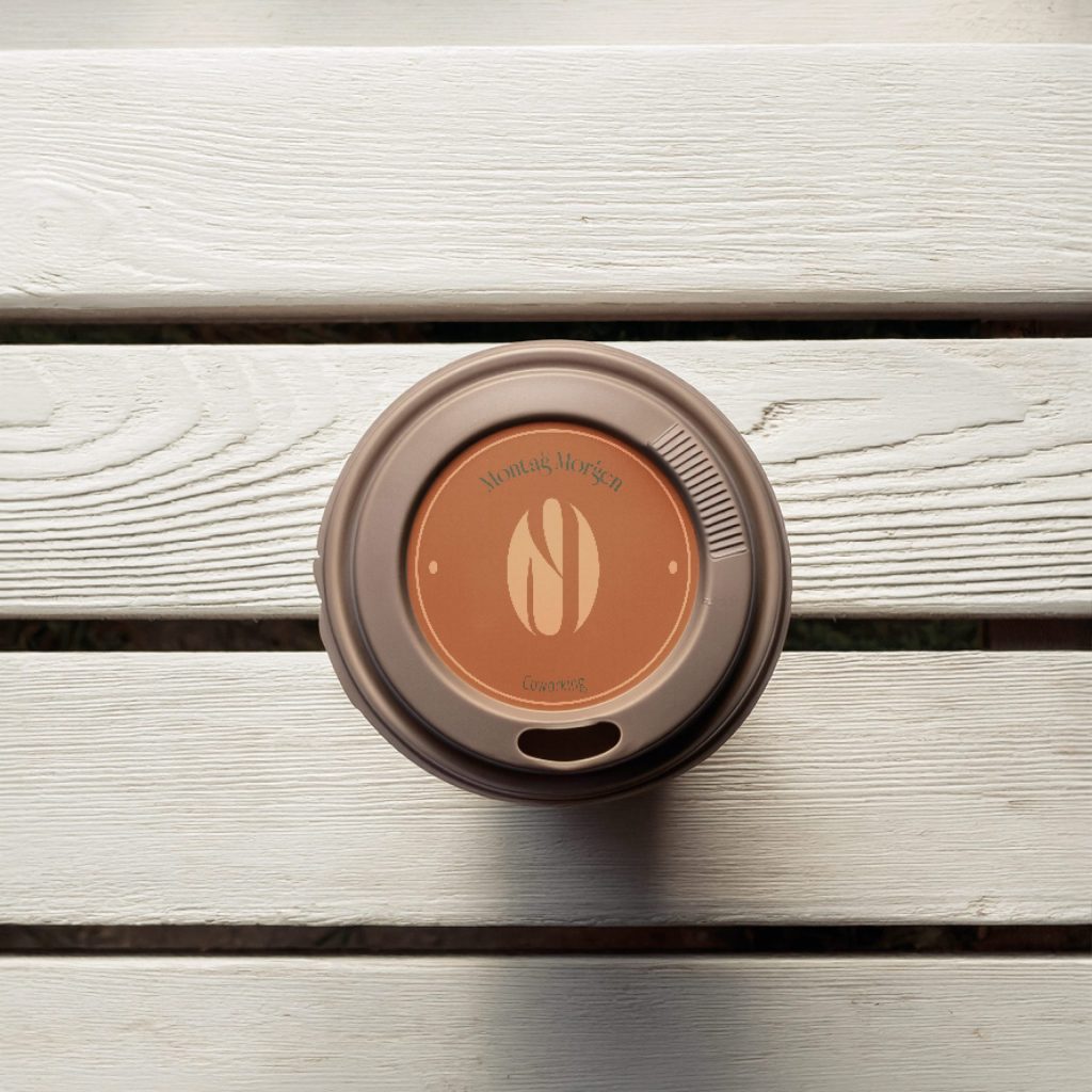 Submark für Montagmorgen dargestellt als Sticker auf einem Kaffeebecher togo Deckel braun/beige | Kremer Signature Design